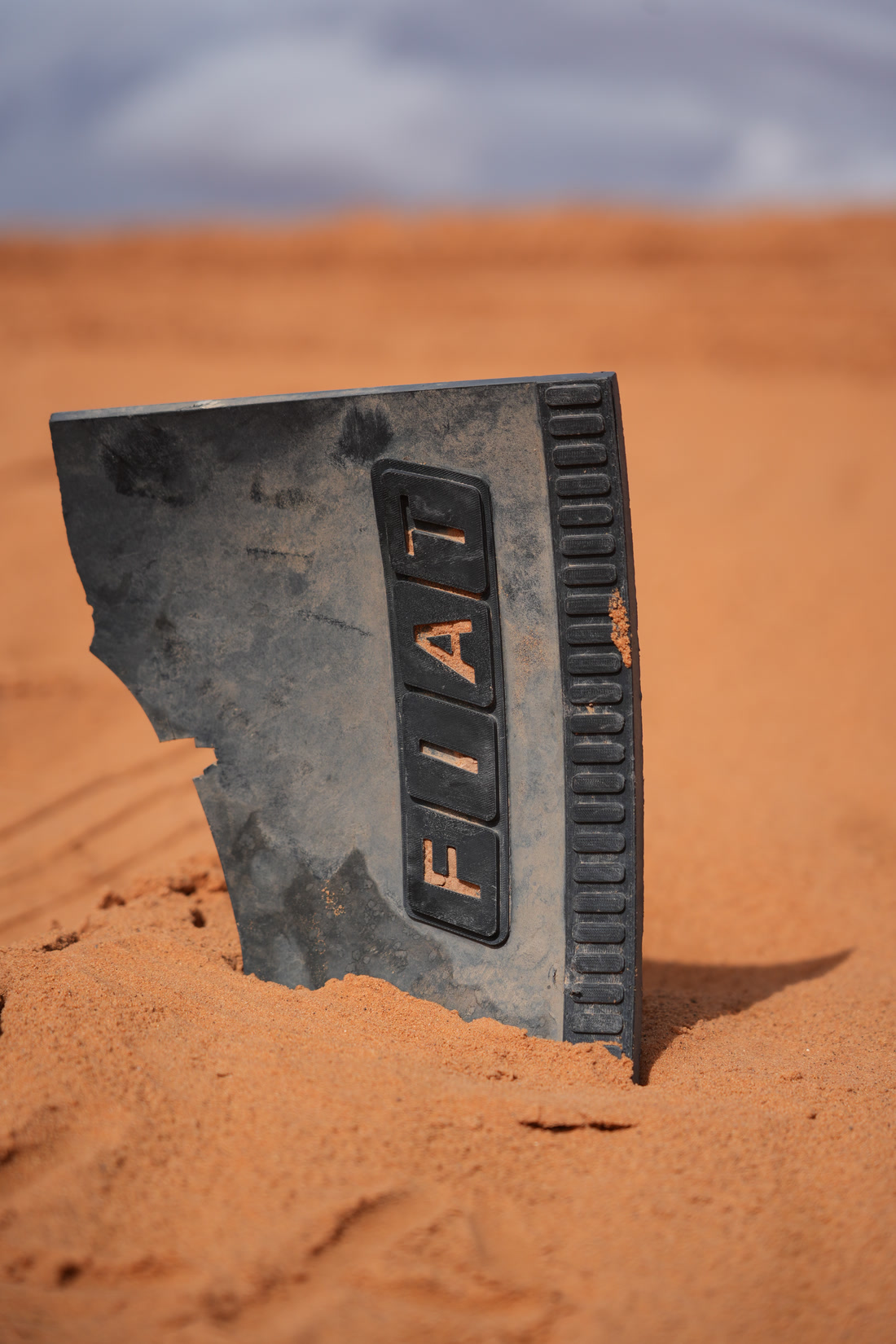 Panel de Fiat semienterrado en la arena del desierto